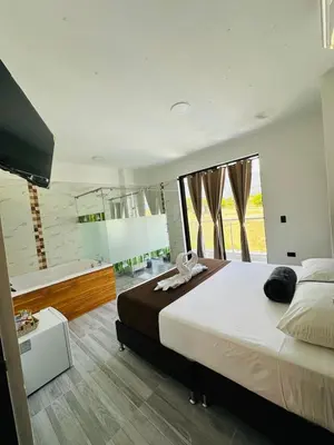 a bedroom with a large bed and a bath tub at Hotel Paraiso Cañaveral in Santa Fe de Antioquia
