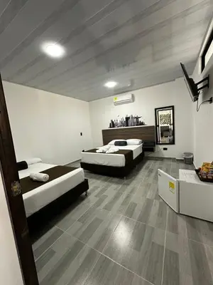 a room with two beds in a room at Hotel Paraiso Cañaveral in Santa Fe de Antioquia