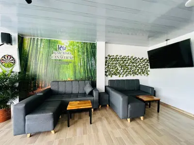 a living room with two couches and a flat screen tv at Hotel Paraiso Cañaveral in Santa Fe de Antioquia