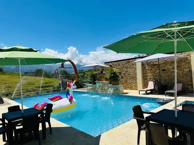 a pool with a person in a boat in the water at Hotel Paraiso Cañaveral in Santa Fe de Antioquia