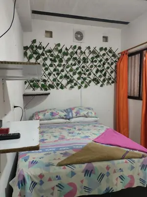a bedroom with a bed with a comforter on it at Hospedaje Bonanza in Santa Fe de Antioquia