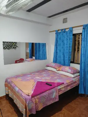 a bed in a room with blue drapes at Hospedaje Bonanza in Santa Fe de Antioquia