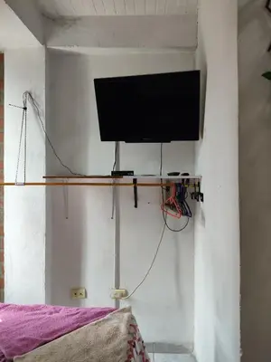 a television on a shelf on a wall at Hospedaje Bonanza in Santa Fe de Antioquia