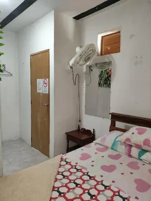 a bedroom with a bed and a phone on the wall at Hospedaje Bonanza in Santa Fe de Antioquia