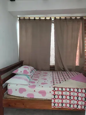 a bedroom with a bed and a window with avertisement at Hospedaje Bonanza in Santa Fe de Antioquia
