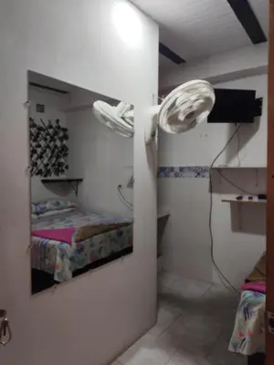 a room with a bed and a mirror on the wall at Hospedaje Bonanza in Santa Fe de Antioquia