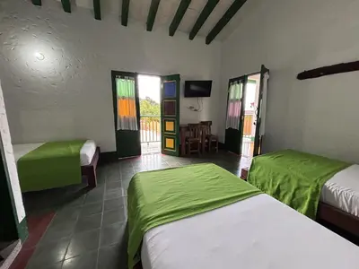 a bedroom with two beds and a table and chairs at Hotel Vegas del Rio in Támesis