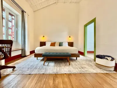 a bedroom with a bed and a bench and a table at Elegant Colonial Walkable Casa in Jericó