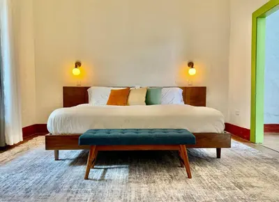 a bedroom with a large bed with a bench in it at Elegant Colonial Walkable Casa in Jericó