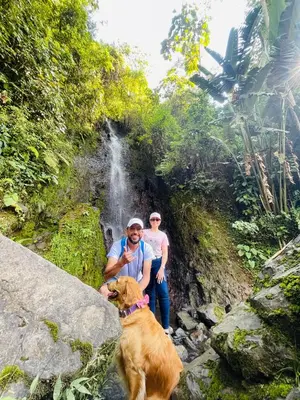 two people and a dog in front of a waterfall at Apartamento Privado en el Centro, Programación de Tours y Mas in Jardin