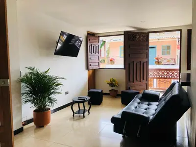a living room with a couch and a potted plant at Apartamento Privado en el Centro, Programación de Tours y Mas in Jardin