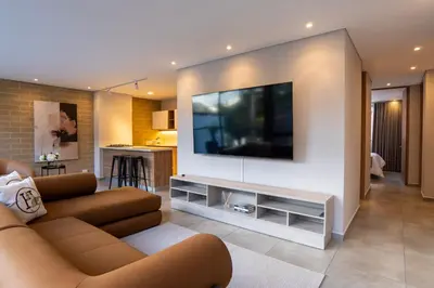 a living room with a couch and a flat screen tv at 99Rentall in Medellín