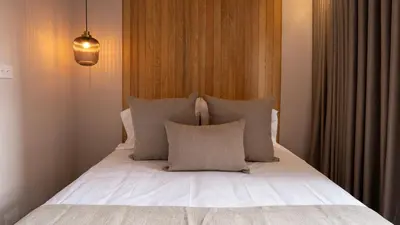 a bedroom with a bed with white sheets and pillows at 99Rentall in Medellín