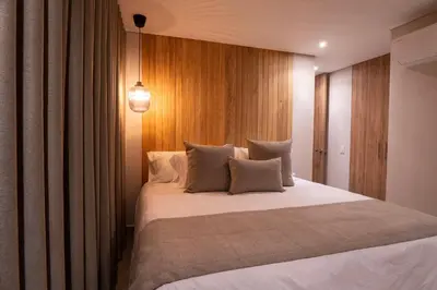 a bedroom with a large white bed with wooden walls at 99Rentall in Medellín