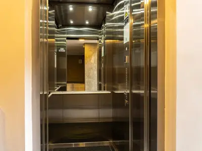 a glass elevator in a hallway in a building at 99Rentall in Medellín