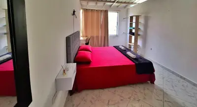 a bedroom with a red bed and a window at OSIMiRI CUERVOS in San Rafael