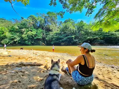 a woman sitting on the beach with a dog at OSIMiRI CUERVOS in San Rafael