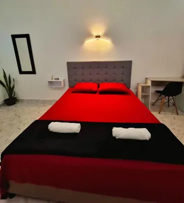 a bedroom with a large red bed with red pillows at OSIMiRI CUERVOS in San Rafael