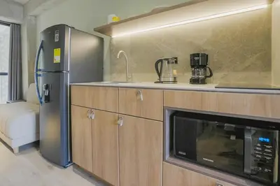 a kitchen with a microwave and a refrigerator at BRENT 30 Living in Medellín