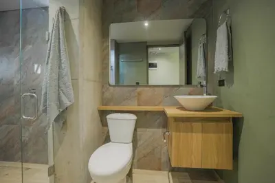 a bathroom with a toilet and a sink and a mirror at BRENT 30 Living in Medellín