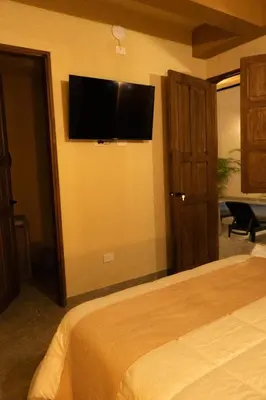 a bedroom with a bed and a flat screen tv on the wall at Hotel Boutique Lomas Colonial in Santa Fe de Antioquia