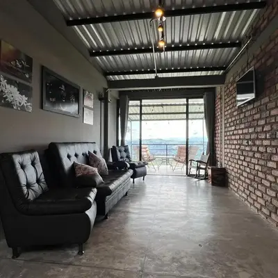 a living room with couches and a brick wall at Don Café - Luxury and confort in Manizales