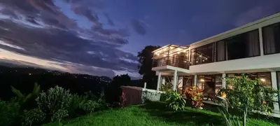 a house on the side of a hill at night at Don Café - Luxury and confort in Manizales