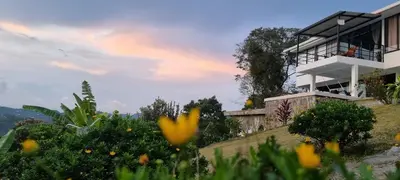 a house on top of a hill with flowers at Don Café - Luxury and confort in Manizales