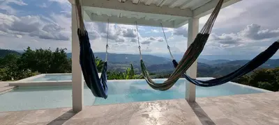 two hammocks hanging from a porch next to a swimming pool at Don Café - Luxury and confort in Manizales