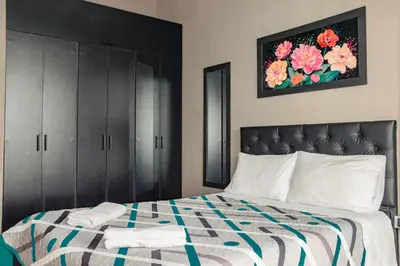 a bedroom with a bed with black cabinets and flowers at Don Café - Luxury and confort in Manizales