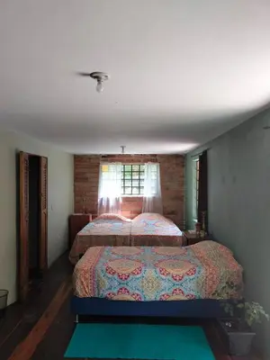 a bedroom with a bed and a window at Casa Rosa de los Vientos in oak forest in Medellín
