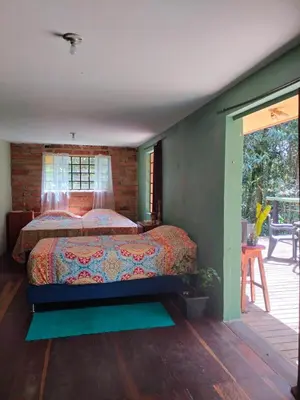a bedroom with a bed in a room with a patio at Casa Rosa de los Vientos in oak forest in Medellín