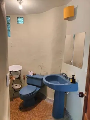 a bathroom with a blue toilet and a sink at Casa Rosa de los Vientos in oak forest in Medellín