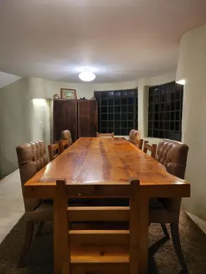 a wooden table in a room with chairs around it at Casa Rosa de los Vientos in oak forest in Medellín