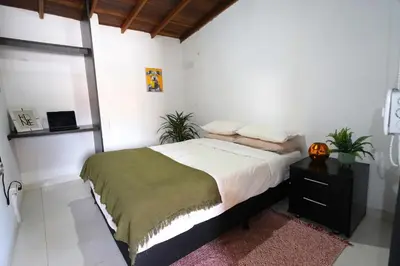 a bedroom with a large bed and a night stand at Hogar De Ensueño in Envigado