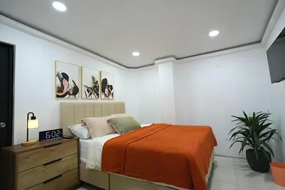 a bedroom with a bed with an orange blanket at Hogar De Ensueño in Envigado