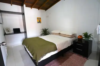 a bedroom with a bed with a night stand and a pumpkin at Hogar De Ensueño in Envigado