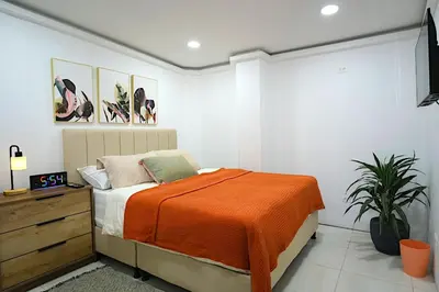 a bedroom with a bed with an orange blanket at Hogar De Ensueño in Envigado