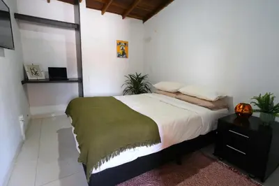 a bedroom with a large bed and a night stand at Hogar De Ensueño in Envigado
