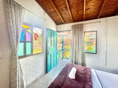 a room with a bed and a window and a door at Casa de 7 habitaciones cerca al pueblo de Guatapé in Guatapé