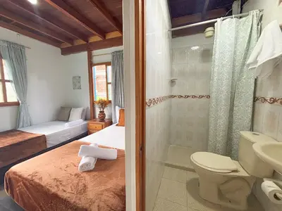 a bathroom with a bed and a shower and a toilet at Casa de 7 habitaciones cerca al pueblo de Guatapé in Guatapé