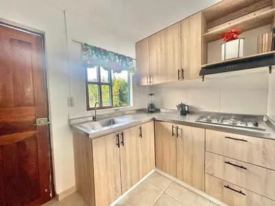 a kitchen with wooden cabinets and a sink and a window at Casa de 7 habitaciones cerca al pueblo de Guatapé in Guatapé