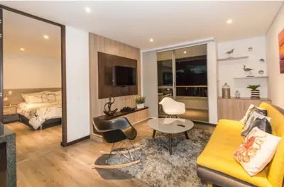 a living room with a yellow couch and a bed at aparta hotel campestre luxury en llanogrande 10 minutos aeropuerto in Rionegro