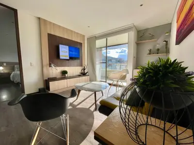 a living room with a table and chairs and a tv at aparta hotel campestre luxury en llanogrande 10 minutos aeropuerto in Rionegro