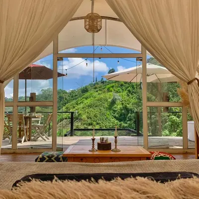 a living room with a table and a view of a mountain at Moonshine - Sereno Glamping in Manizales