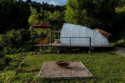 a bird sitting on a table in the grass at Moonshine - Sereno Glamping in Manizales