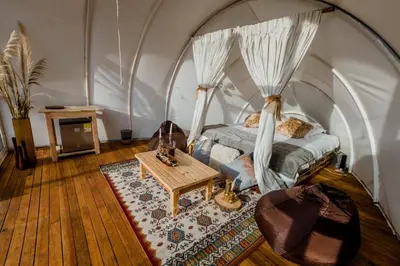 a bedroom with a bed and a table in a room at Moonshine - Sereno Glamping in Manizales