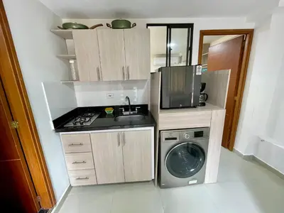 a small kitchen with a washing machine and a microwave at laureles zona turistica estadio cerca poblado aire acondicionado in Medellín