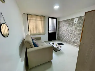 a living room with a couch and a brick wall at laureles zona turistica estadio cerca poblado aire acondicionado in Medellín