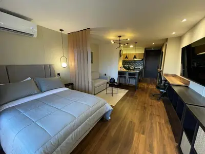 a bedroom with a large bed and a living room at Premium Studio near Oviedo Mall, El Poblado- Balcony, AC & Fast WiFi in Medellín